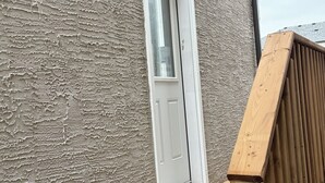 A wooden deck with a white door and a textured wall. - Haven in the Prairies (2BR Suite) (Winnipeg)