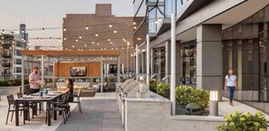 Dine al fresco in a stylish outdoor space with tables, chairs, and a barbecue grill.