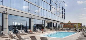 Relax by the pool surrounded by lounge chairs and umbrellas.
