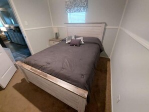 Cozy retreat with a single bed, bedside table, and lamp.