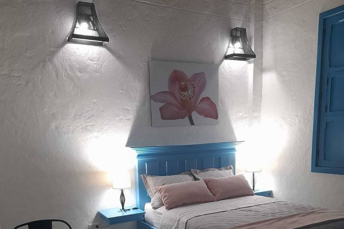 Un dormitorio con una cama, un escritorio y una silla.