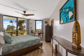 Ein modernes Schlafzimmer mit Bett, Schreibtisch und Balkon.