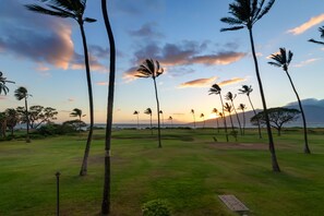 Ein Golfplatz mit Palmen und Blick auf den Sonnenuntergang.