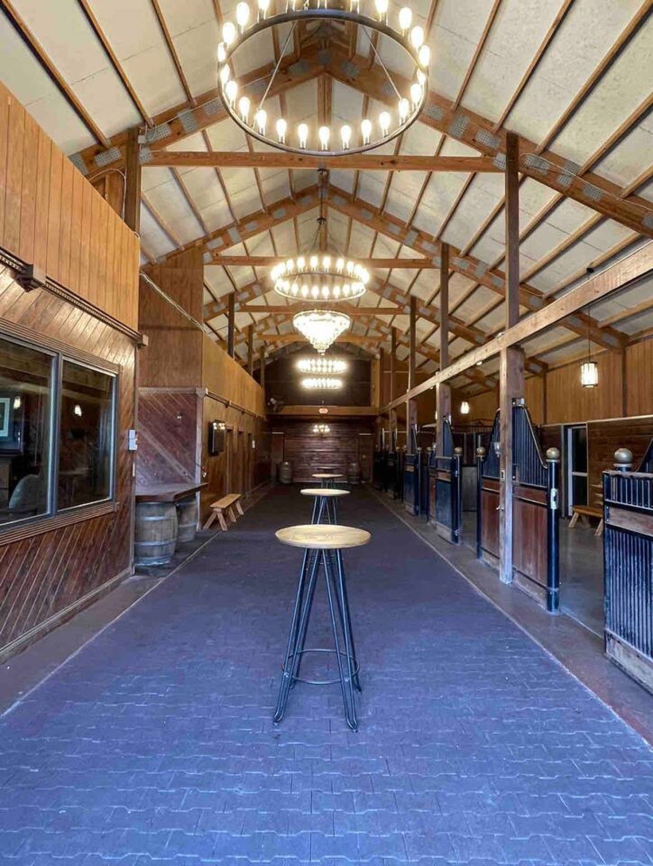 Rummelig indretning med hvælvet loft, træbjælker og en stor lysekrone i midten. Der er siddepladser med bænke og en lang gang.