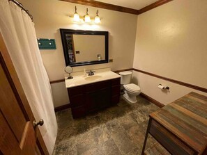 A bathroom with a sink, mirror, and toilet.