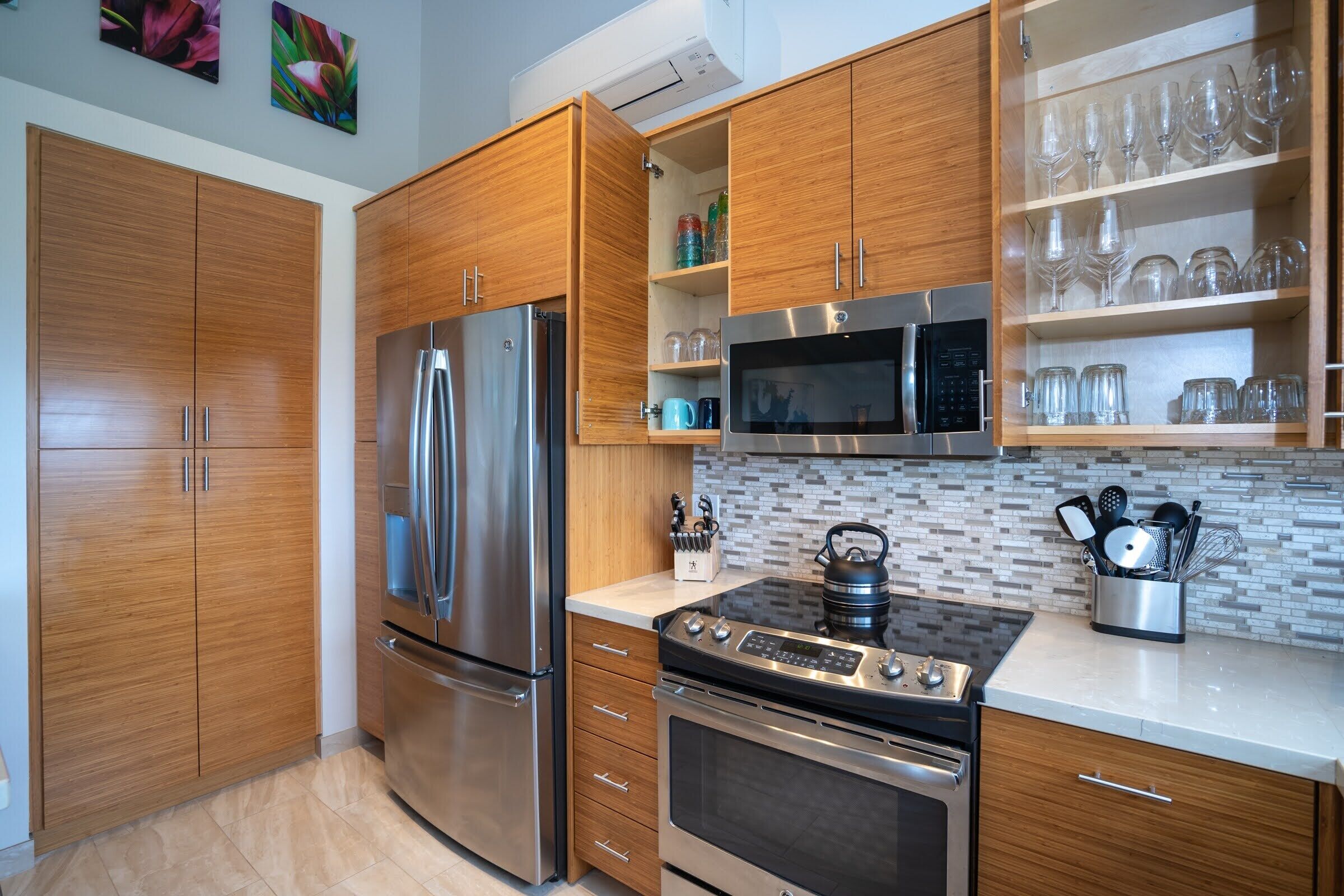 A modern kitchen with wooden cabinets, stainless steel appliances, and a tiled backsplash.