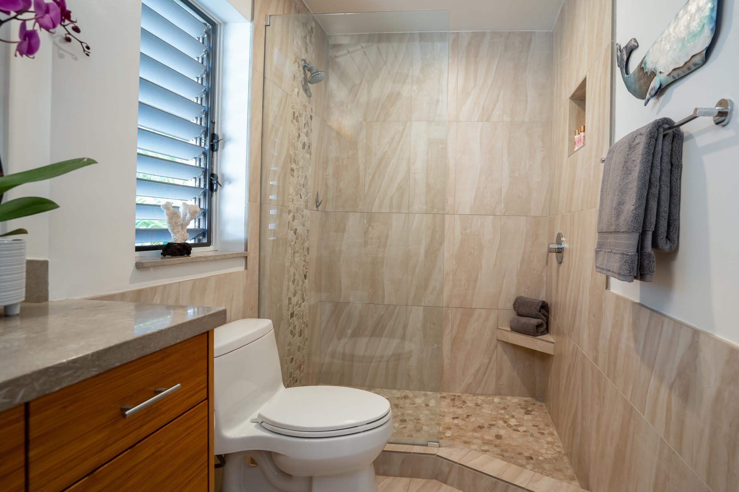 A bathroom with a shower, toilet, and sink.
