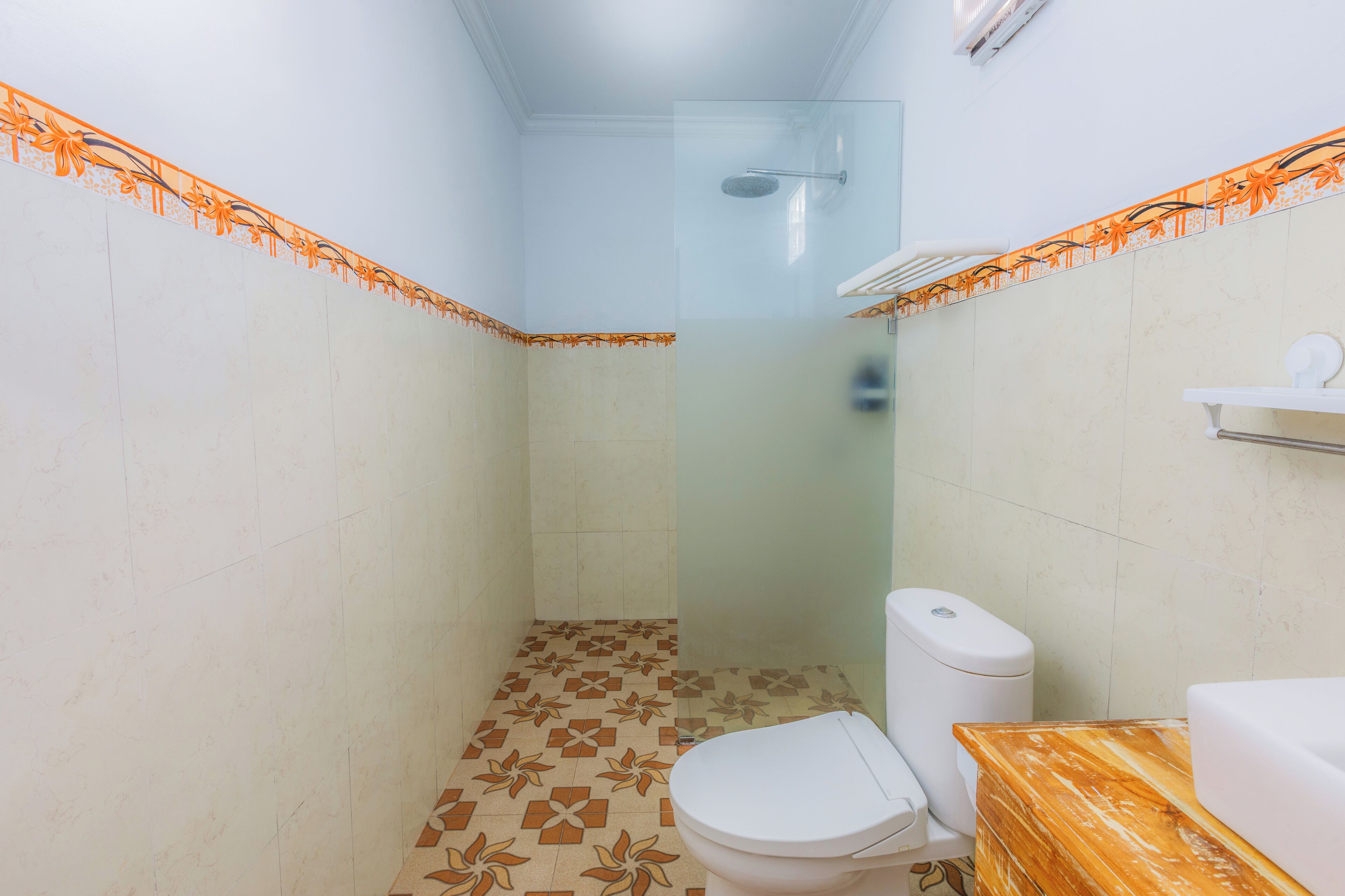 A small bathroom with a toilet, a shower, and a sink.