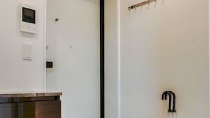 A modern bathroom with a wooden vanity, a toilet, a towel rack, and a shower area. - 2023 Open/Shinjuku Okubo/5 mins to JR/200M Wi-Fi (Shinjuku City)