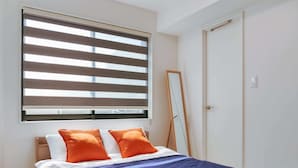 A bedroom with a bed, a window with blinds, a mirror, and a door. - 2023 Open/Shinjuku Okubo/5 mins to JR/200M Wi-Fi (Shinjuku City)