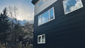 Un bâtiment moderne à deux étages, doté de grandes fenêtres et d’une façade sombre.