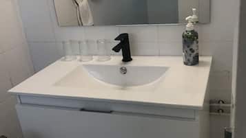 Chuveiro, toalhas de banho, papel higiênico