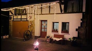 Experience the rustic charm of this traditional building, featuring a brick-paved entrance and a warm fire pit.