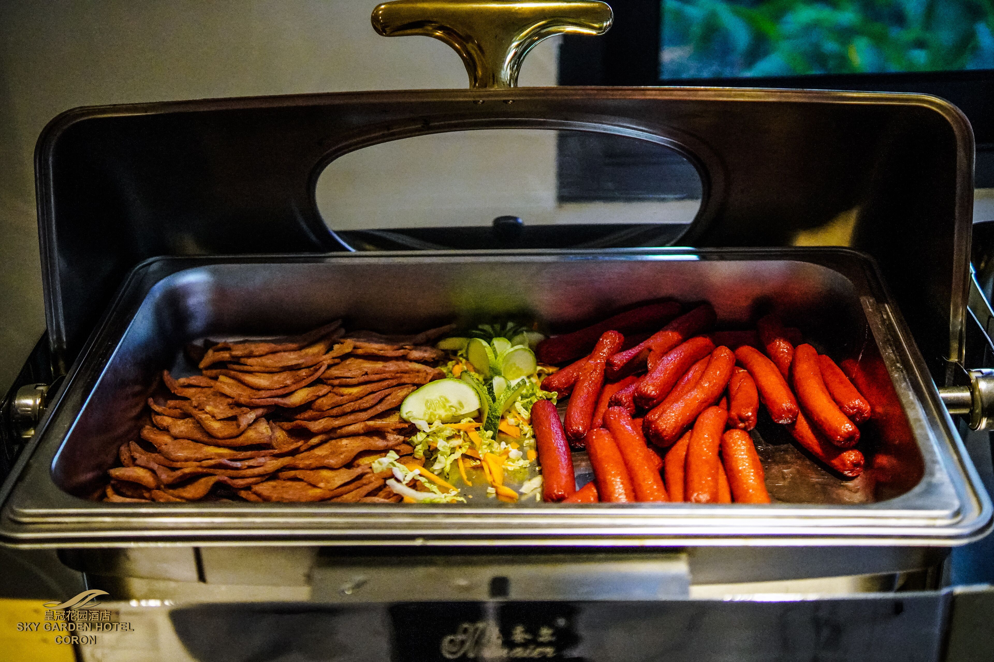 A buffet with various food items including sausages, carrots, and other vegetables.