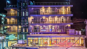 A multi-story hotel with balconies, air conditioning units, and a restaurant on the ground floor. - Sky Garden Hotel (Coron)