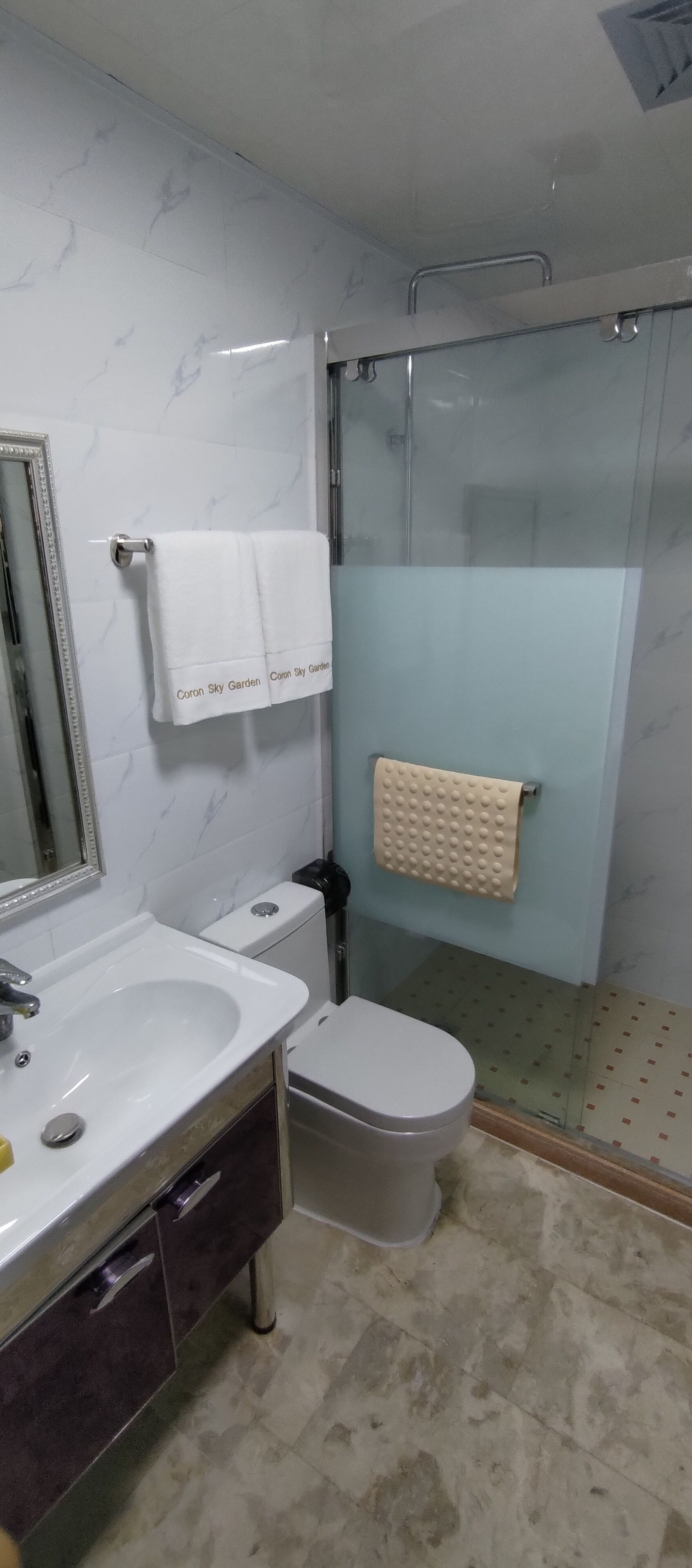 A bathroom with a white sink, a toilet, and a glass shower enclosure.