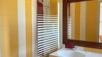 A bathroom with a white bathtub, a white sink, and a mirror above the sink.