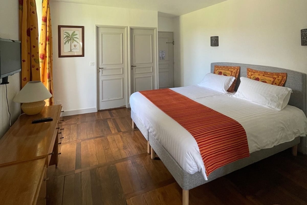 Une chambre à coucher avec un lit, un bureau, une lampe et une chaise.