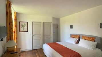 Un dormitori amb un llit, escriptori, làmpada i una cadira.