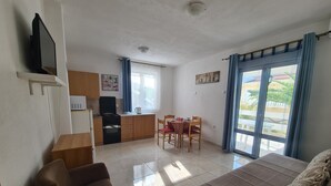 A compact living space with a kitchenette, a dining area, and a sofa. - Apartment for 4 persons (Bar)