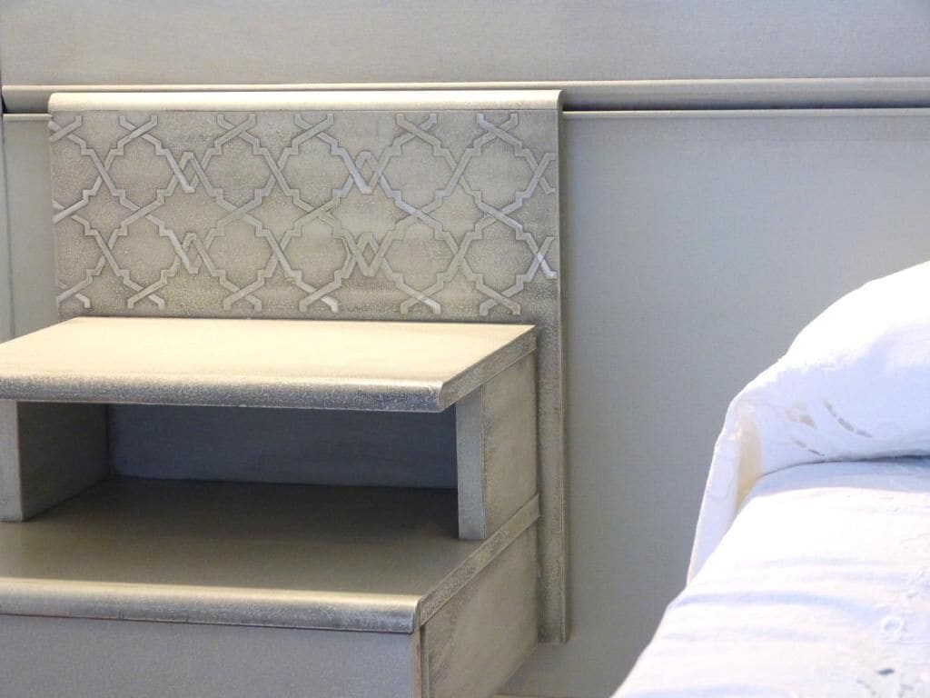 A bed with a headboard featuring a geometric pattern.