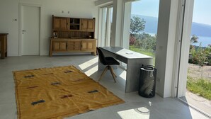 A modern kitchen with wooden cabinets, a dining area with a table and chairs, and a large window offering a view of the outdoors. - Country house on Monte Maderno with 260* lake view on 15000 square meters of parkland (Toscolano Maderno)