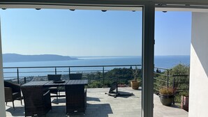 A balcony with a table and chairs, overlooking a body of water and distant hills. - Country house on Monte Maderno with 260* lake view on 15000 square meters of parkland (Toscolano Maderno)