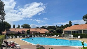 A swimming pool with lounge chairs and a statue.