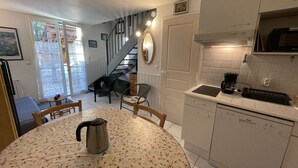 A compact kitchen with a dining table, a kettle, and a coffee maker.