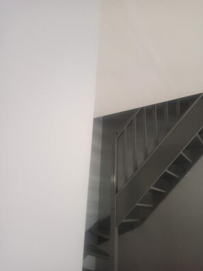 Eine Treppe mit Metallgeländer und weißer Wand.