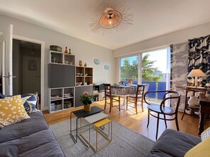 Relax in a stylish living space with a comfortable sofa, dining area, and ample natural light.