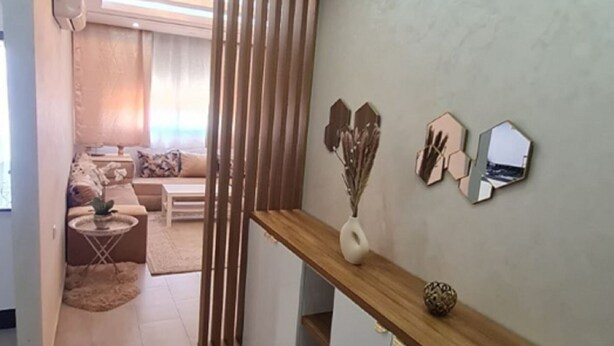 Een moderne woonkamer met een bank, salontafel en decoratieve objecten op een houten console.