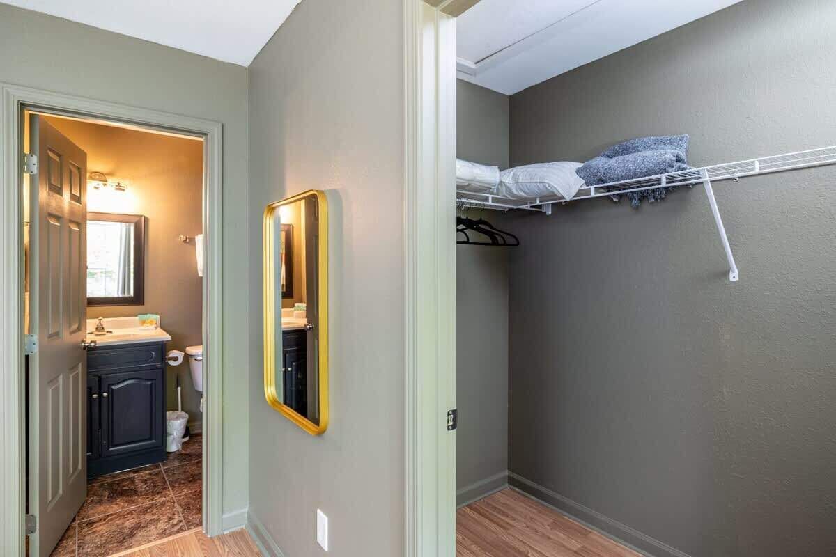 Une petite pièce avec un lit superposé, une minuscule salle de bain comprenant des toilettes et un lavabo, et un miroir au mur.