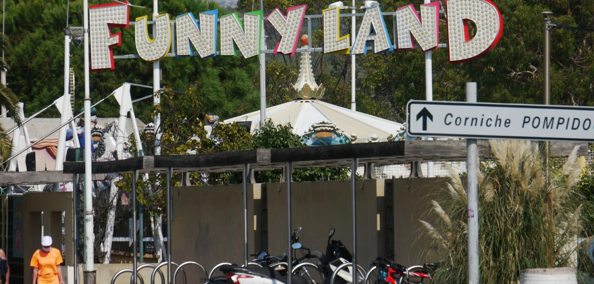 A sign for 'Funny Land' with a directional arrow pointing upwards.