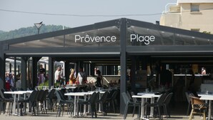 Un café en plein air appelé Provence Plage, avec des tables et des chaises disposées pour accueillir les clients.