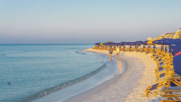 A beach with rows of yellow beach chairs and umbrellas, a sandy shoreline, and a calm sea. - Tradewinds 26 * Across from the beach * Fall Rates * Salt Water Vacations (Miramar Beach)