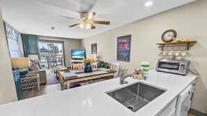 A modern kitchen with a white marble countertop, a built-in sink, and a ceiling fan. - Tradewinds 26 * Across from the beach * Fall Rates * Salt Water Vacations (Miramar Beach)
