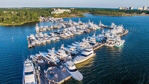 An aerial view of a marina with numerous yachts docked at wooden piers.