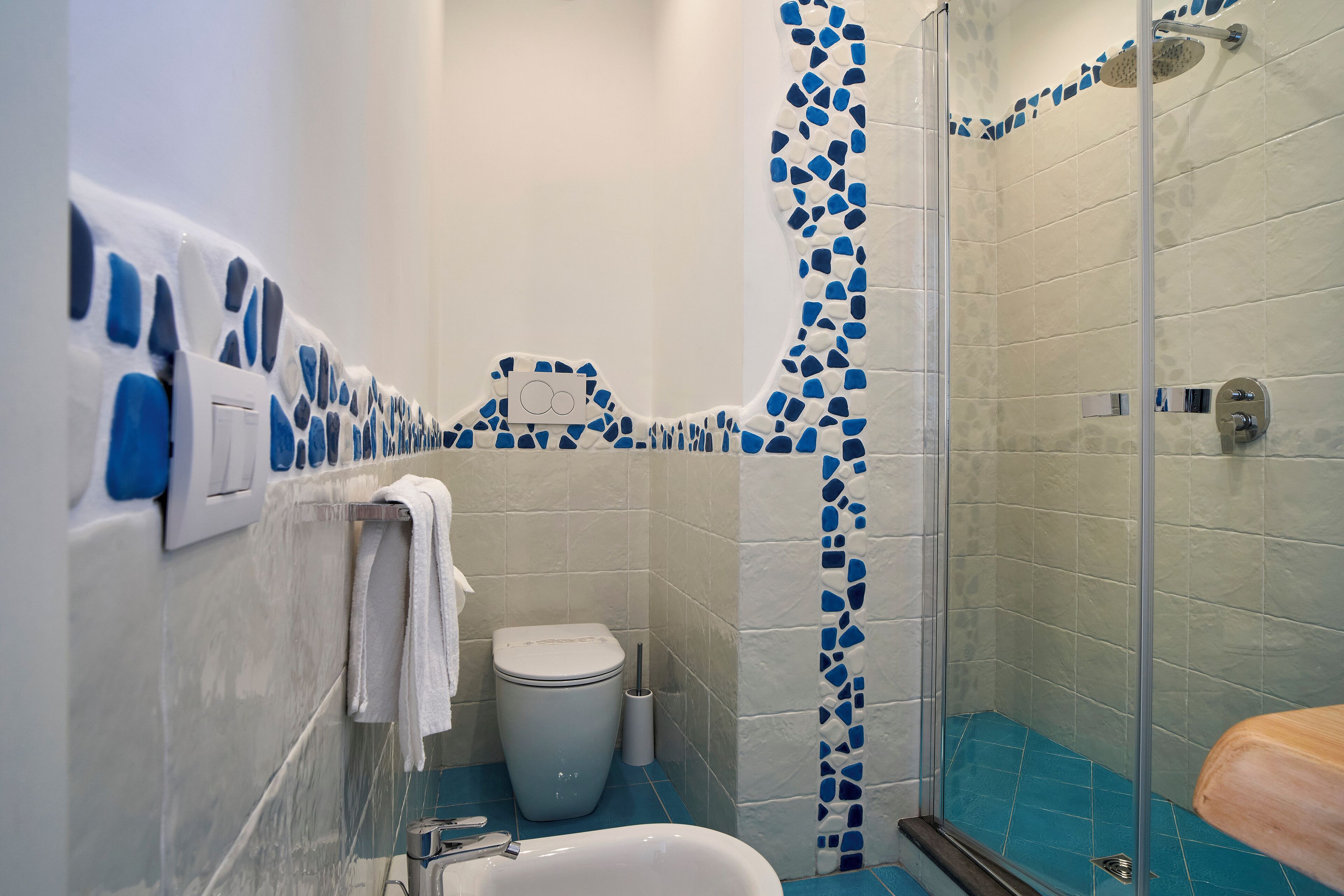 A bathroom with a shower, toilet, and sink.