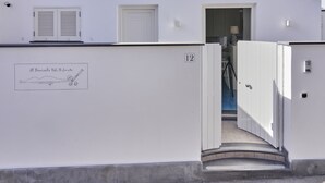A white building with a door labeled "12" and a small window with shutters. - il Truciolo Suite (Anacapri)
