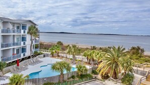 A hotel with a pool, palm trees, and a view of the ocean. - Breezy Palms on the Bay!  Dolphins, Pools, Beach (Tybee Island)