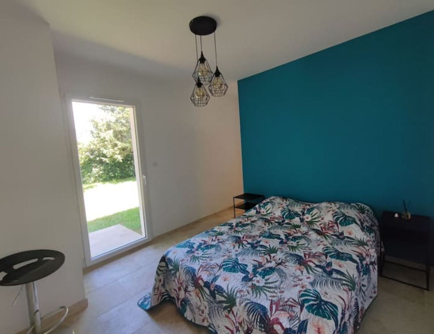 A bedroom with a bed, a window, and a door.