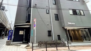 A multi-story building with a modern design, featuring a Total Car Shop on the ground floor. - Near Tsutenkaku, Toy Street, Spacious,Elevator,Wi-Fi,Self check-in, Easy Transit (Osaka)