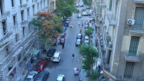 A busy urban street with buildings on either side, vehicles, and pedestrians. - Miramar Evergreen Hotel (Cairo)