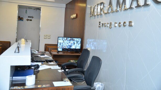 A modern office with a reception desk, multiple monitors, and black office chairs. - Miramar Evergreen Hotel (Cairo)