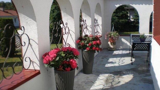 A covered outdoor area with arches and potted plants. - Hotel Getliin (Saku)