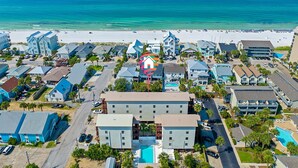 Ein Küstenhotel mit mehreren Gebäuden, einem Swimmingpool und einem Strand im Hintergrund.