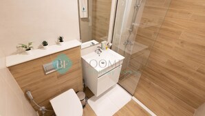 Ein modernes Badezimmer mit Toilette, Waschbecken und Duschkabine.