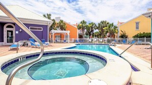 A swimming pool with a hot tub, surrounded by lounge chairs and palm trees. - Coastal Living Perfected: Banana Bay's Intracoastal Retreat with Sandy Shores (Pensacola)