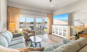 Enjoy a comfortable seating area with a sofa and coffee table, plus a balcony with views of the beach and marina.